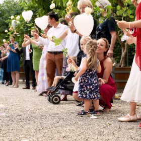 Hochzeitsgäste stehen im Garten Spalier und halten weisse Herzluftballons in den Händen - Herrenhäuser Gärten Hannover © Hochzeitsfotograf www.hochzeitsverliebt.de